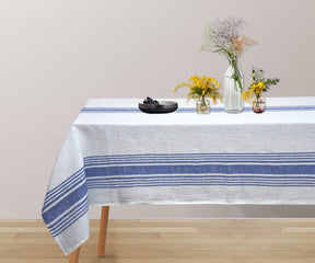 Blue linen tablecloth on a table with a vase of fresh flowers as a centerpiece.