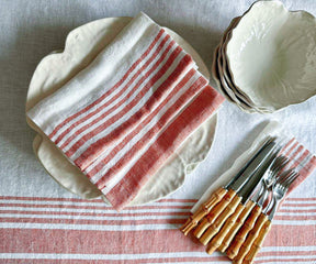 Table setting with white linen tablecloth and dinnerware in place