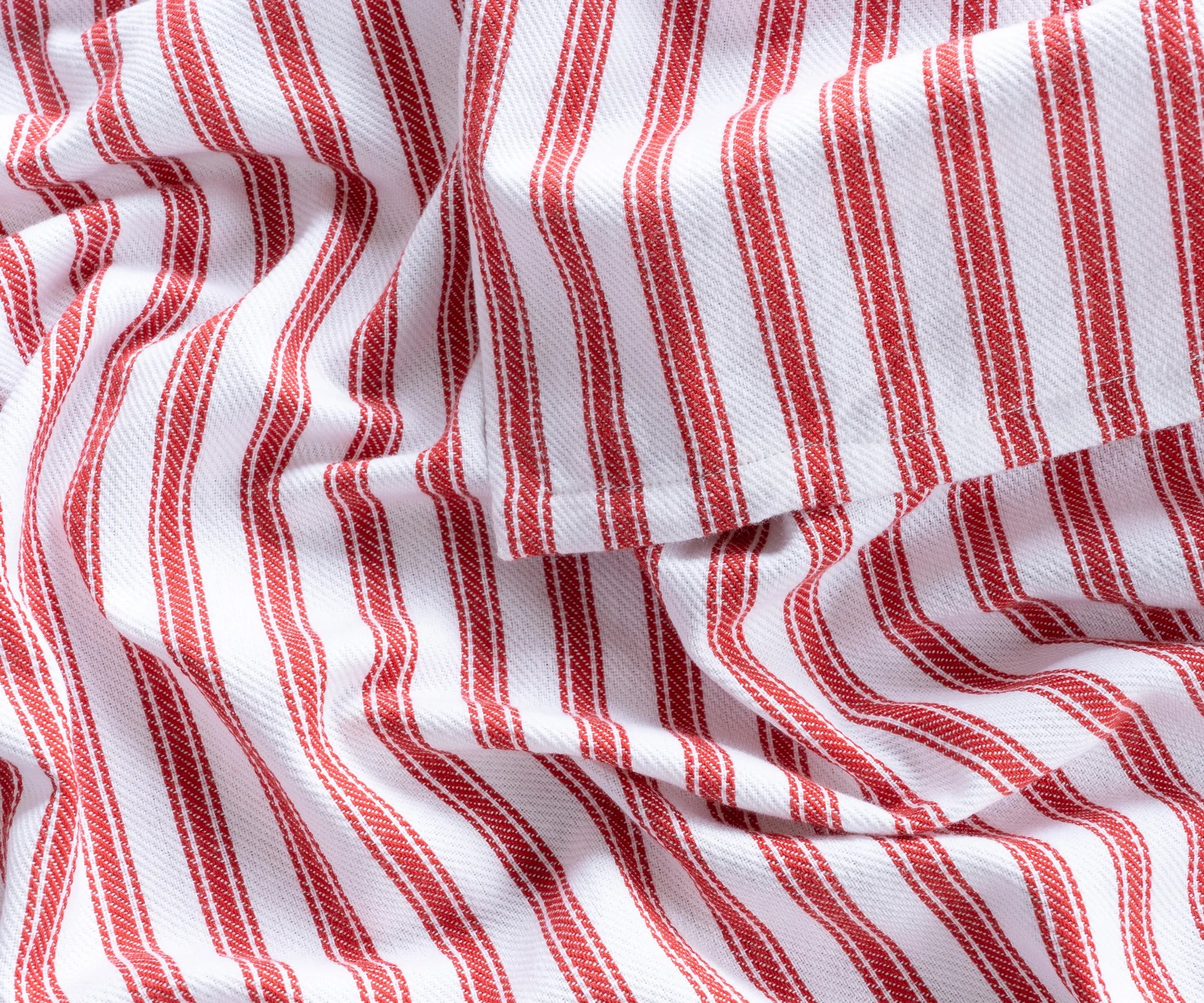 Folded red and white striped round cotton tablecloth