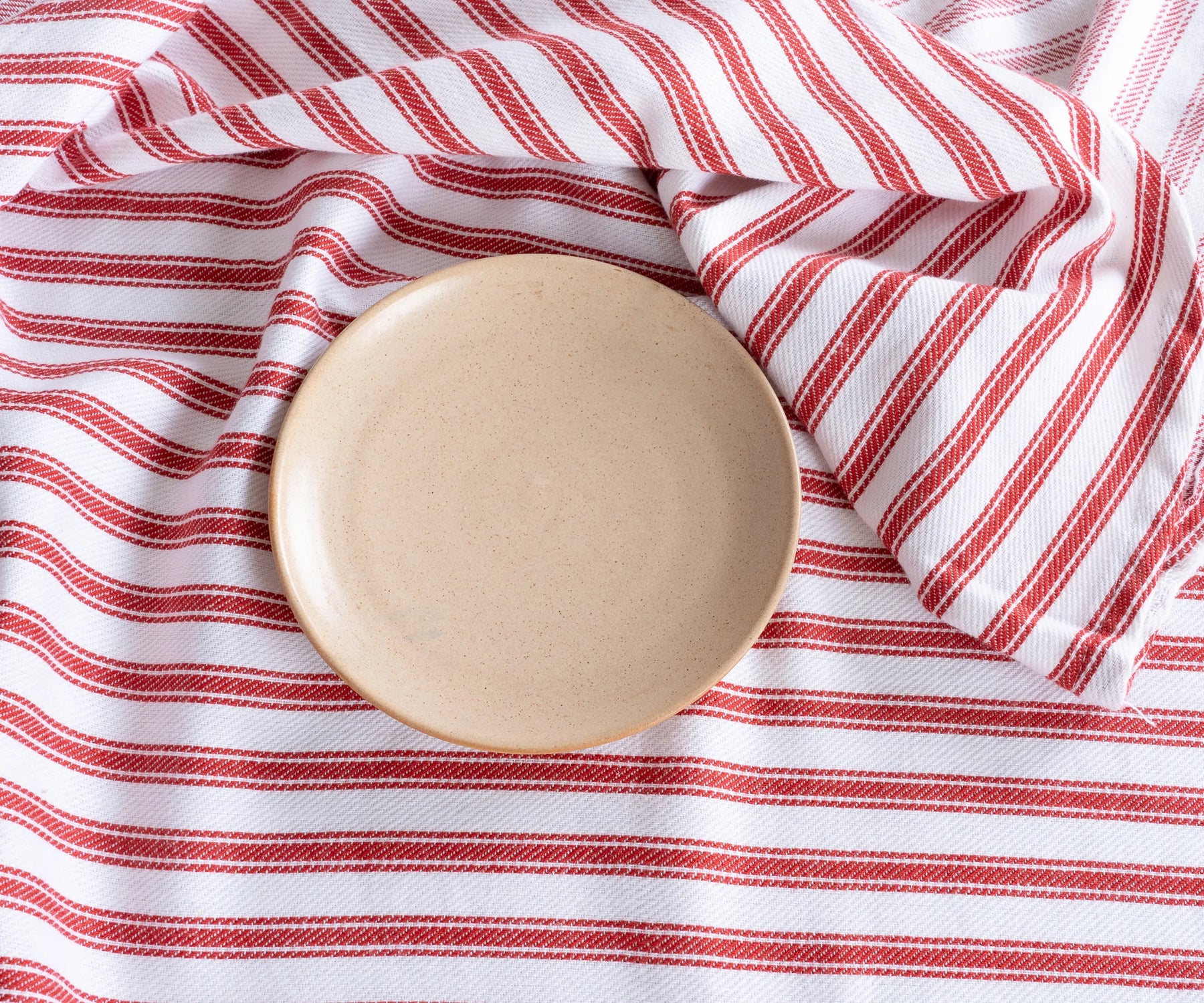 Red ticking round tablecloth on outdoor dining table