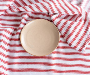 Red ticking round tablecloth on outdoor dining table