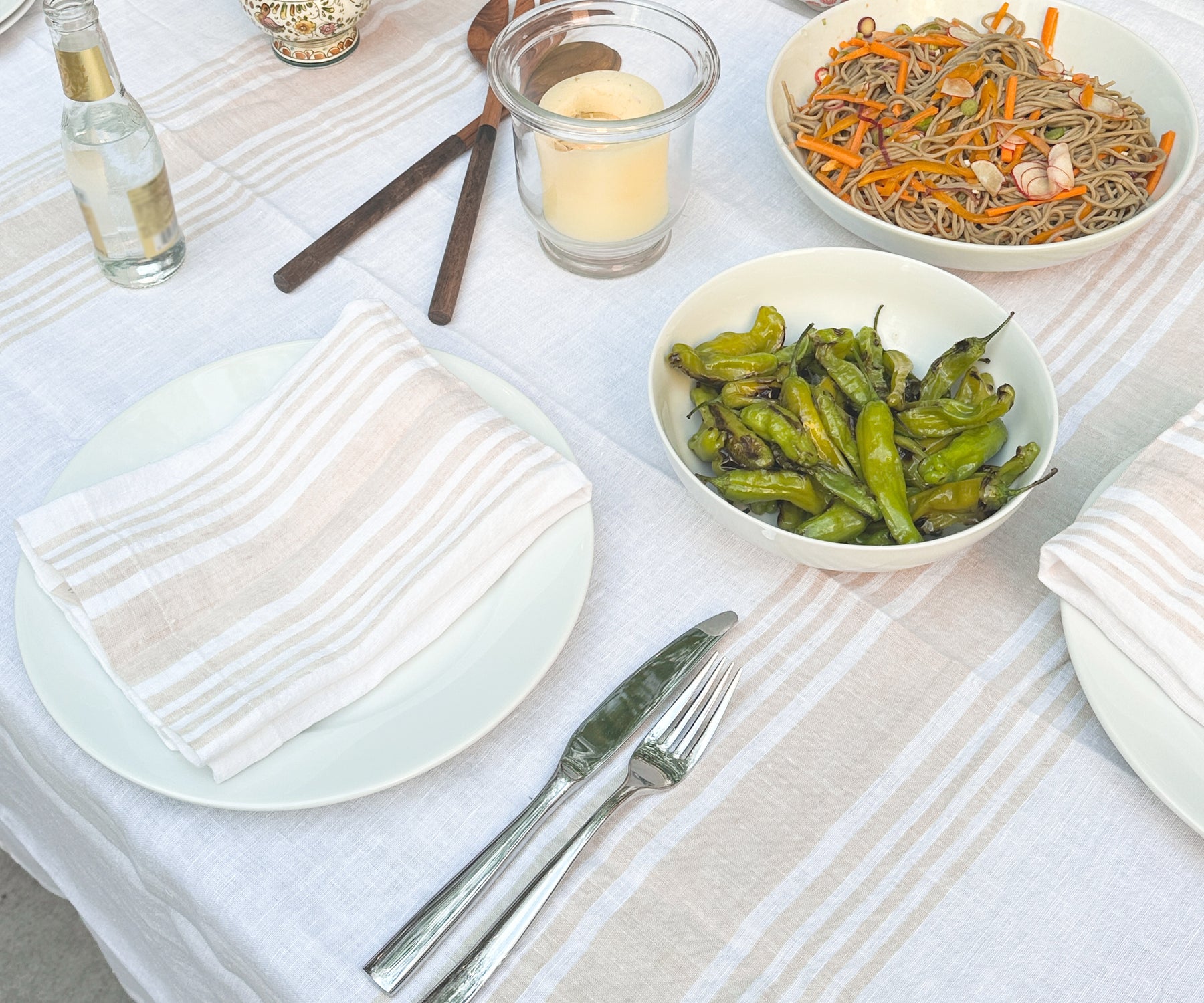 A dining table adorned with a white tablecloth and linen dinner napkins