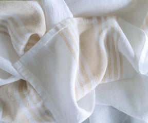 White linen tablecloth with beige stripe accents for an elegant setting