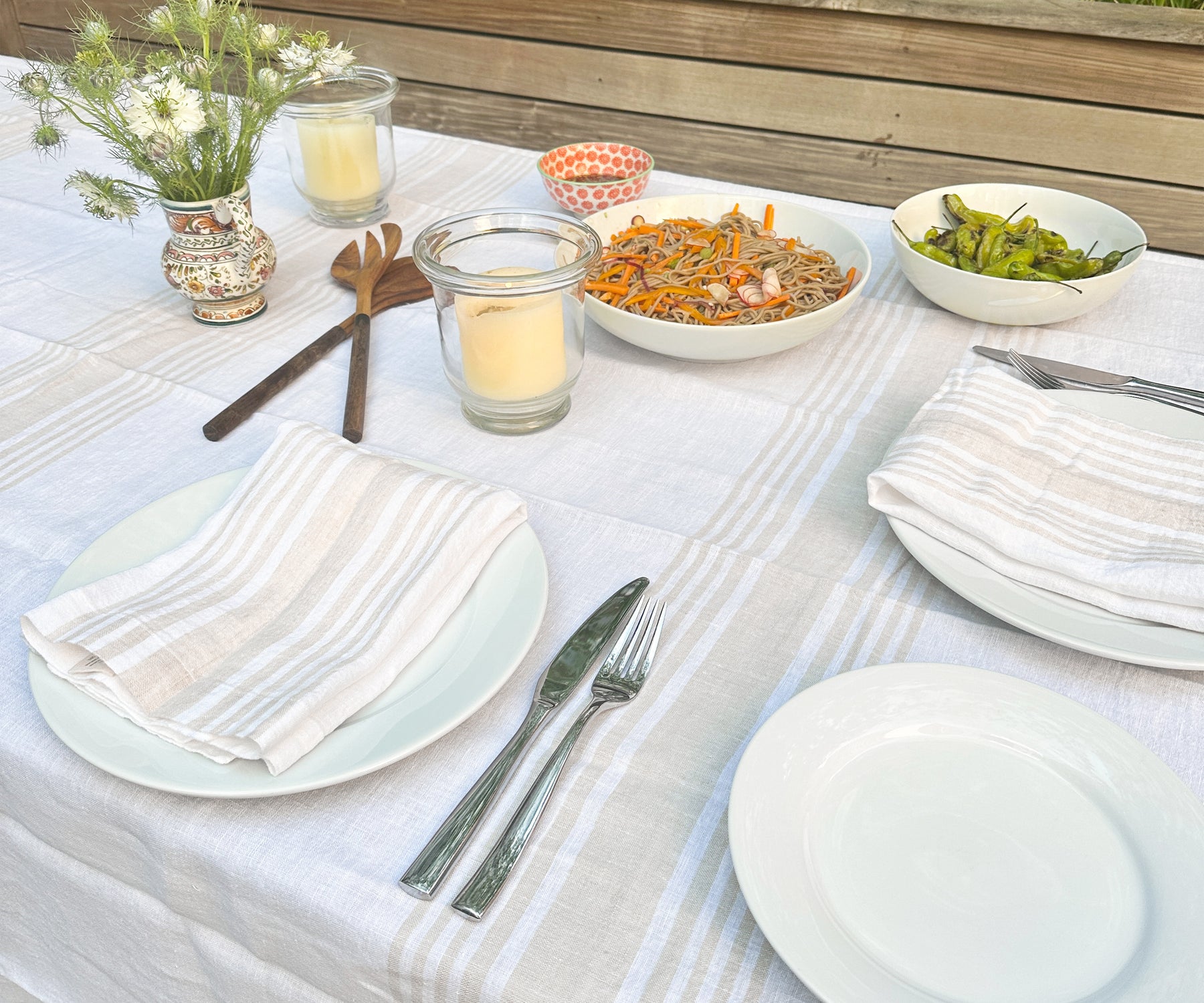 A dining table adorned with a white tablecloth and linen dinner napkins