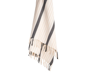 Soft cotton throw blanket with classic black and white stripes and subtle accents, styled for a modern living room