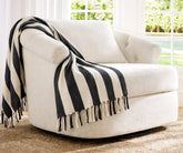 Decorative striped throw blanket placed on a cozy chair adding warmth and texture to a modern living room,throw throw blankets