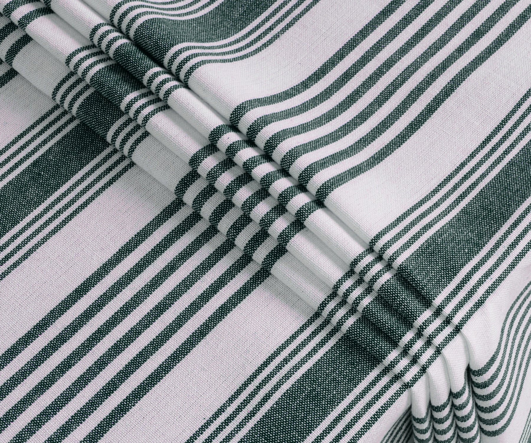 Green and white striped rectangular tablecloth with soft drape on dining table