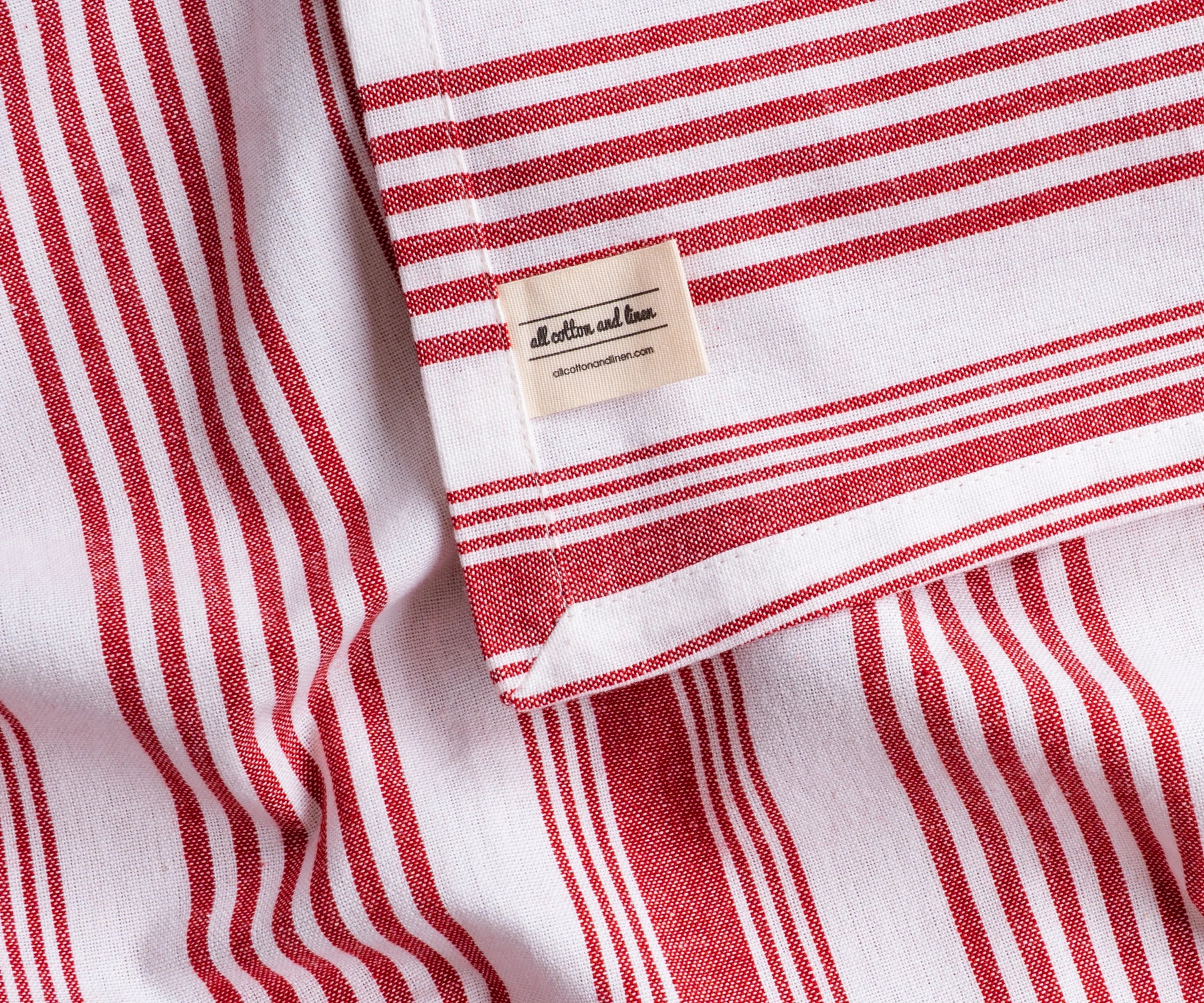 Red and white striped rectangular tablecloth with elegant drape, classic cotton dining table linen