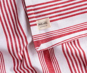 Red and white striped rectangular tablecloth with elegant drape, classic cotton dining table linen