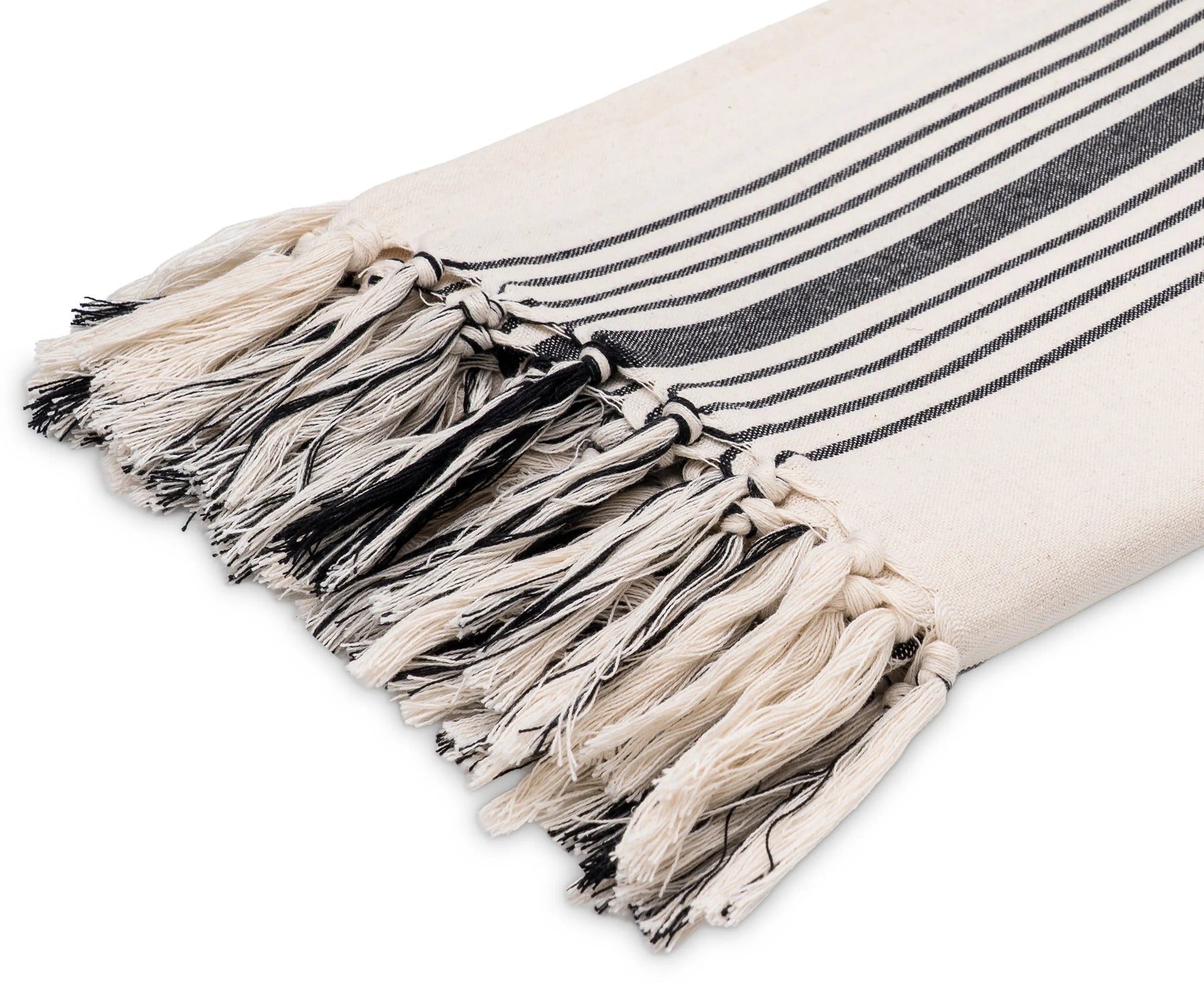 Lightweight black and white cotton throw with fringe detail, adding a cozy and modern accent to a living space