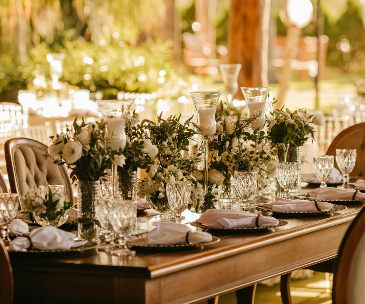 Outdoor wedding reception setup with round tables and floral centerpieces.