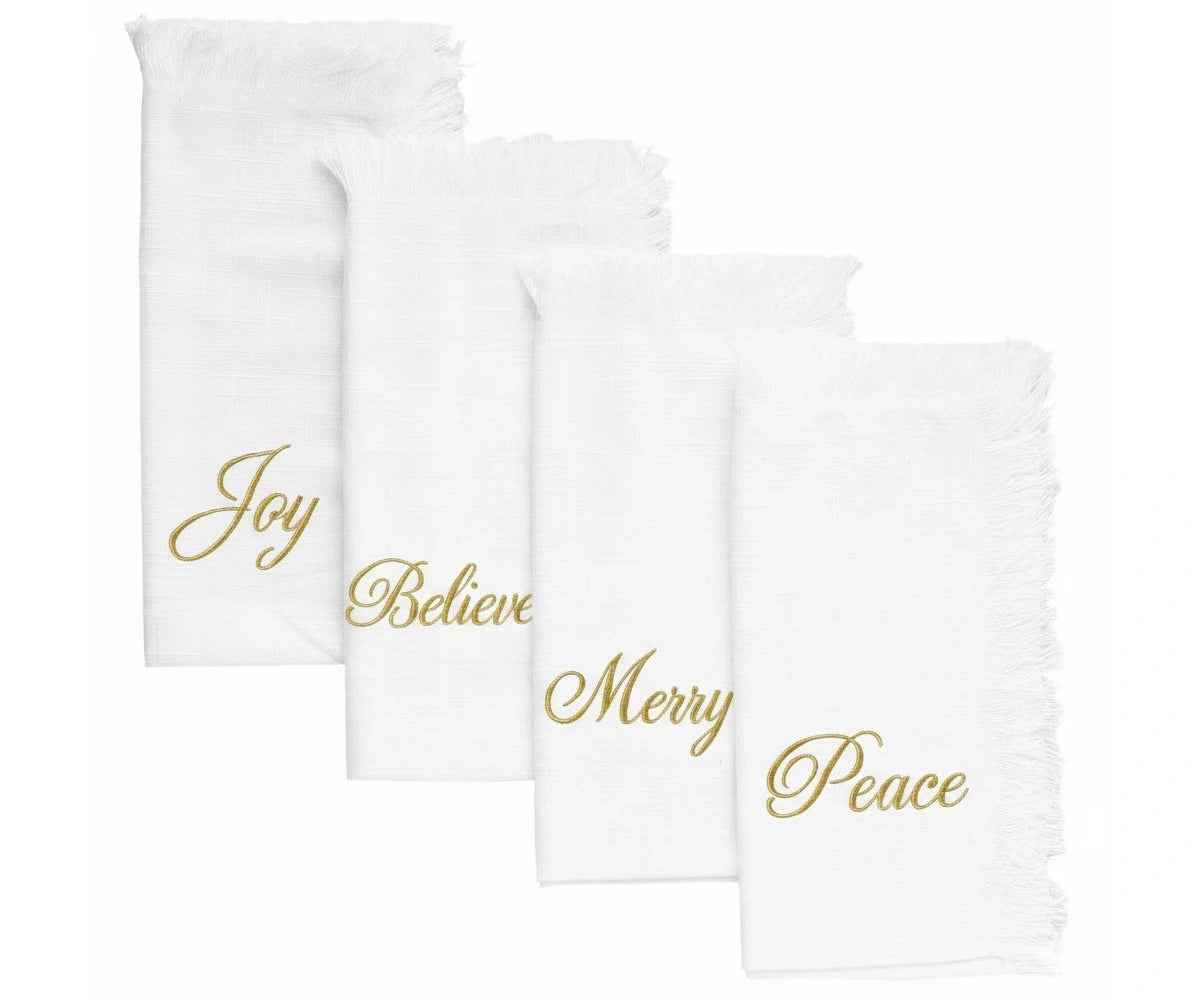 White cotton fringe napkins with gold embroidered Joy, Believe, Merry & Peace – perfect for Christmas and holiday tables