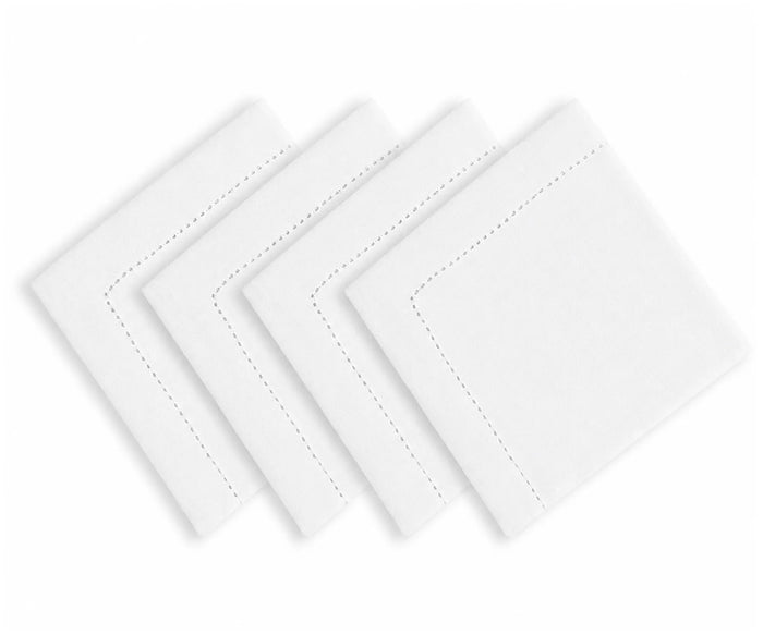 White hemstitched cotton linen blend dinner napkins arranged on an elegant dining table with classic dinnerware and neutral tablecloth