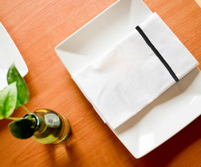 Black cloth napkins elegantly folded to complement a romantic dinner setup.
