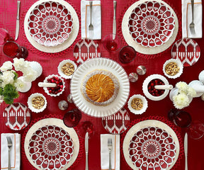 White dinner napkins included in a red table setting with white plates