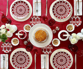 White dinner napkins included in a red table setting with white plates