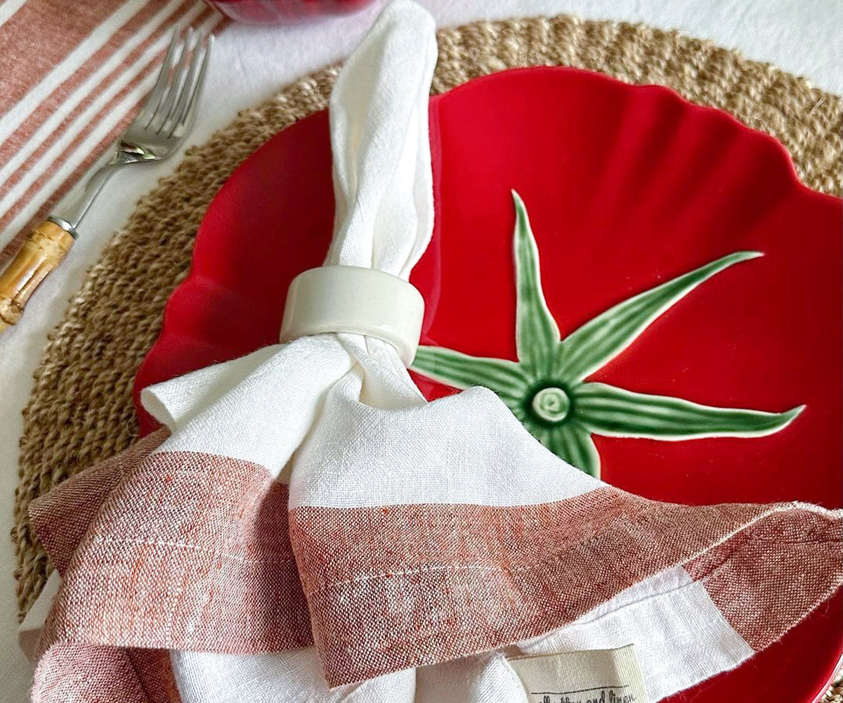 A dining set with red linen napkin rolled with a napkin ring