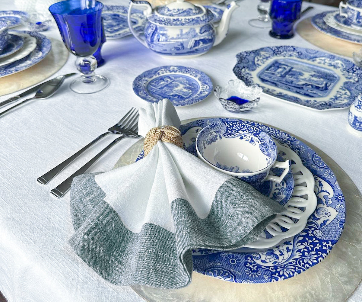 A stack of colourful cloth napkins with linen cocktail napkins on the side