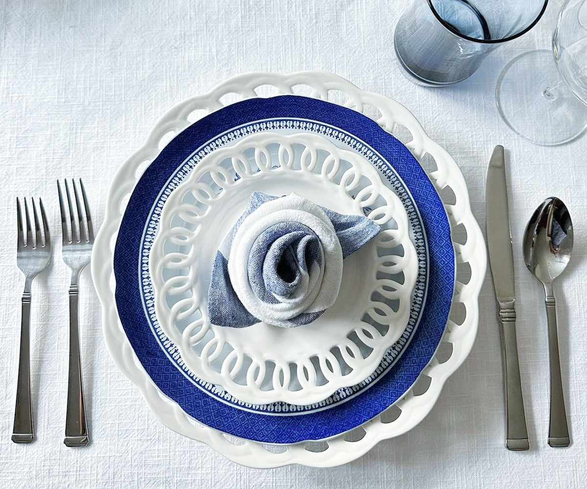 White napkin folded into a bishop's mitre placed on fine china.