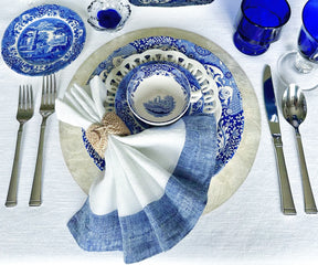 Collection of elegantly folded white napkins on a ceramic dinner set