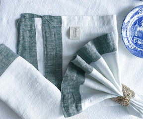 Beautifully folded green linen napkins on a dining table setup