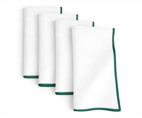 White base cotton napkins detailed with green merrow stitching for casual and festive dining tables
