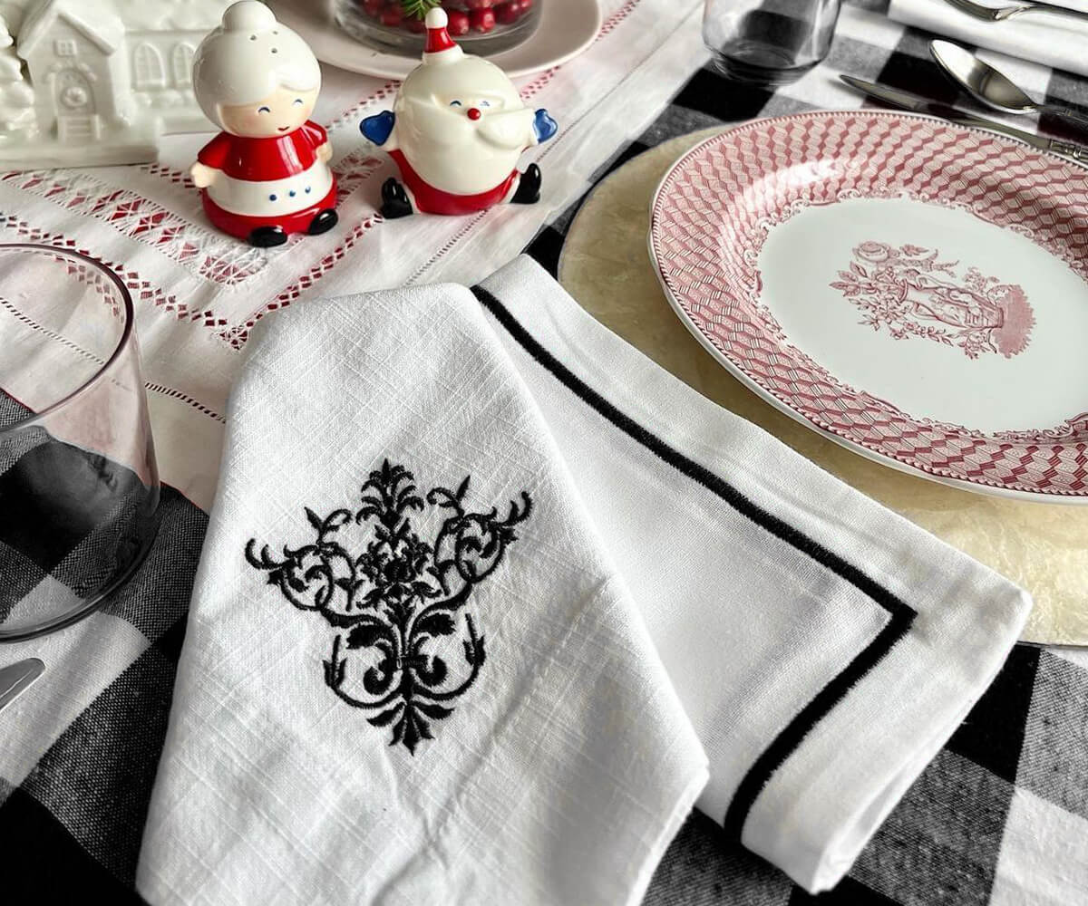Christmas themed table setting featuring a white dinner napkin