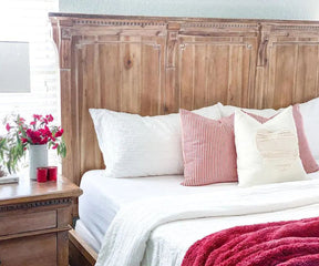 Bed featuring red and white cotton fitted sheets and pillows