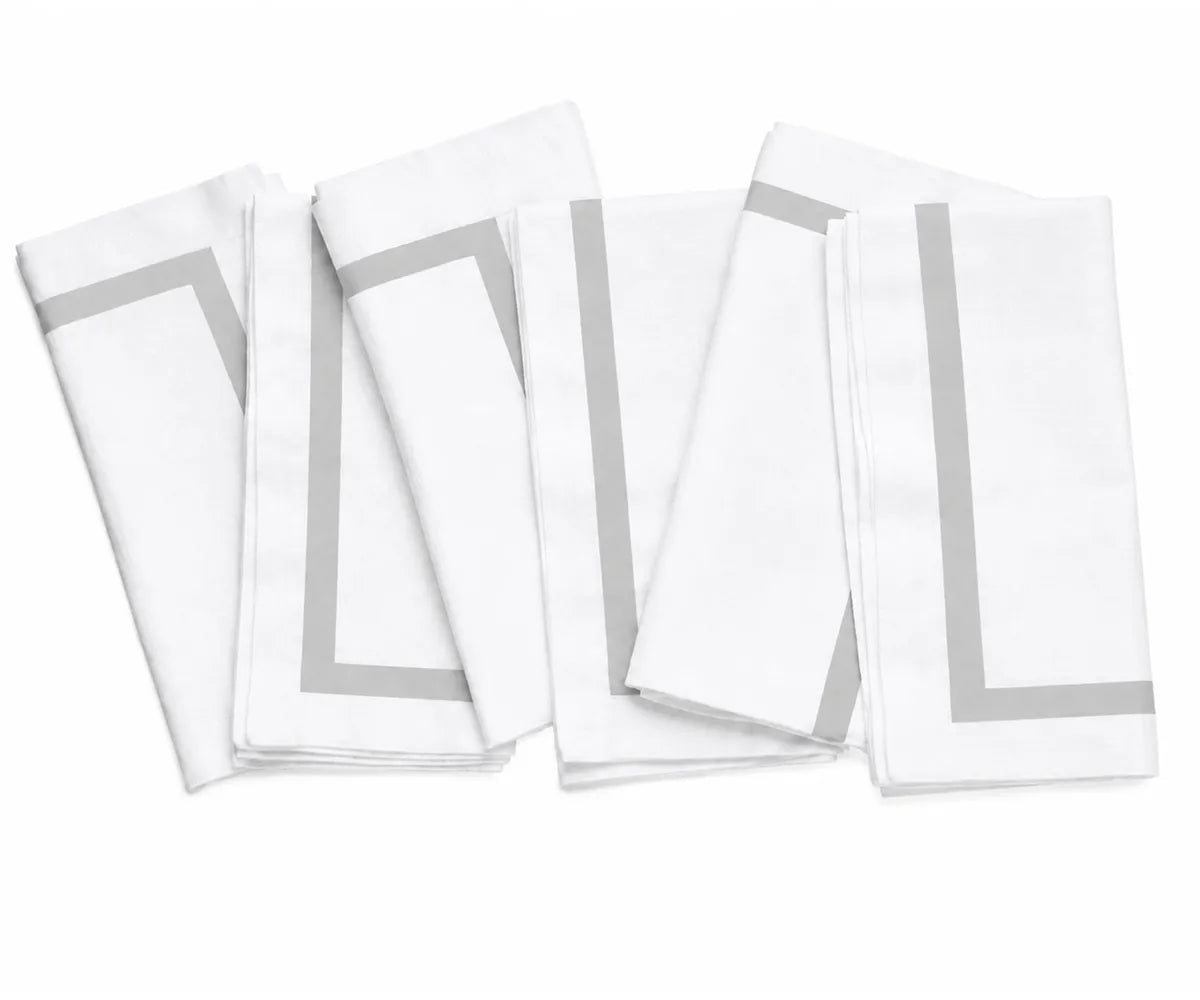Decorative white cloth napkin with colorful edging, bringing subtle visual detail to an elegant dining arrangement.