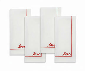 Set of white cotton cloth napkins with minimalist embroidered detail.