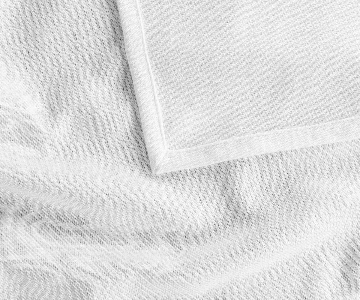 Crisp white rectangle cotton tablecloth neatly spread on a wooden table, paired with neutral runners and rustic tableware for a clean and stylish tablescape.
