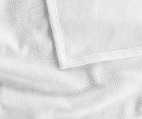Crisp white rectangle cotton tablecloth neatly spread on a wooden table, paired with neutral runners and rustic tableware for a clean and stylish tablescape.