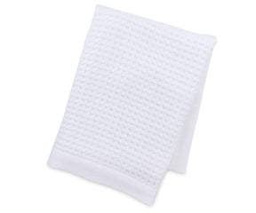 A styled bathroom scene featuring luxury white waffle towels draped beside a bathtub, emphasizing their plush texture, elegant look, and superior absorbency. Perfect for spa-like home settings