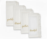 White cotton fringe napkins with gold embroidered words Grateful, Blessed, Gather, Thankful