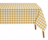Yellow checked tablecloth styled with white dinnerware and natural woven placemats. 