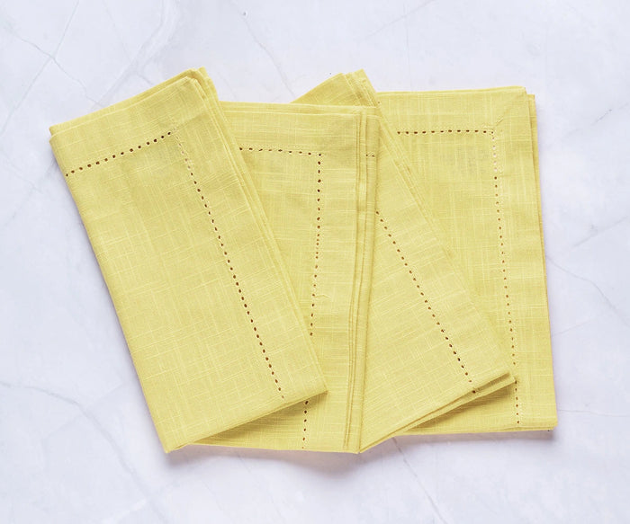 Close-up of hemstitch detailing on butter yellow cloth napkin
