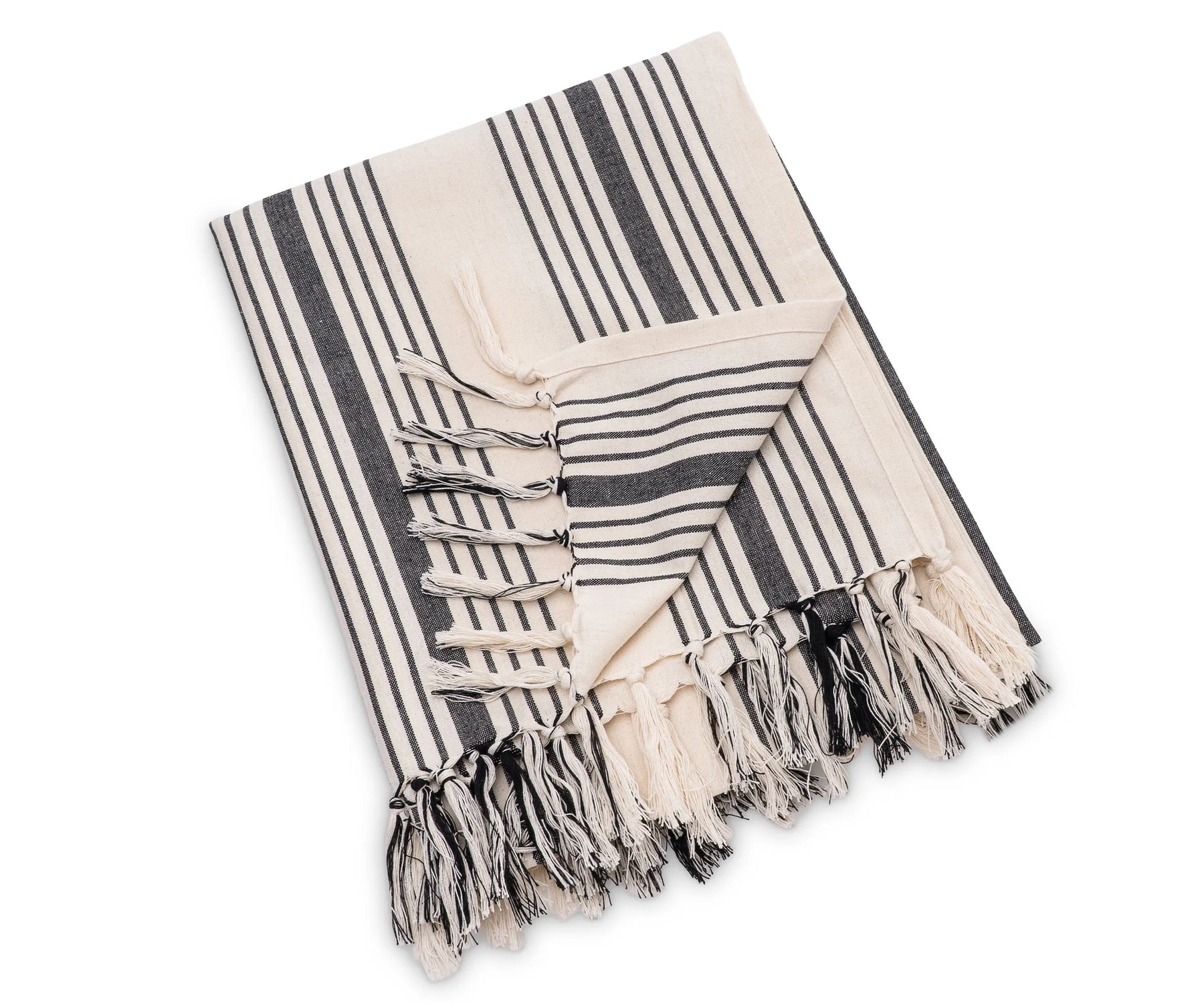 Striped cotton throw blanket draped over a chair, designed for year-round comfort and versatile home styling
