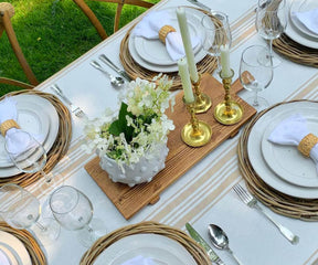 Rustic farmhouse tablecloth elegantly set with white and gold dinnerware