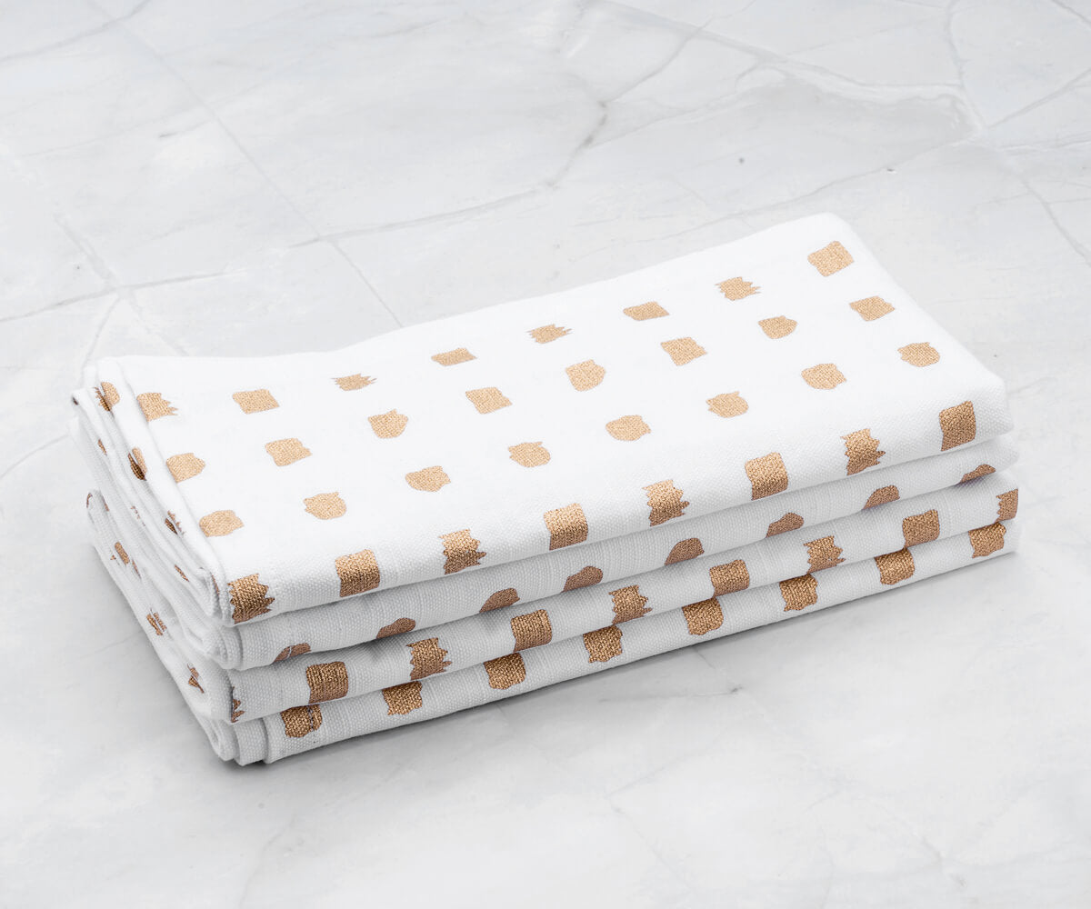 Linen napkins - Metallic linen napkins are arranged on the white floor.