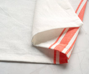 Blue and white striped bistro napkin displayed on a marble counter with red lighting