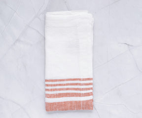 Red striped linen dinner napkin presented on a marble tabletop