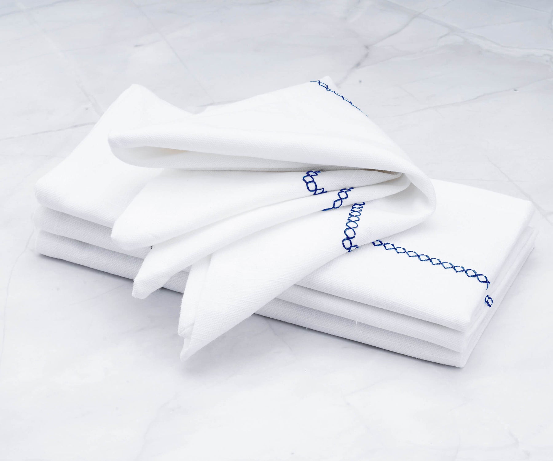 There are cloth dinner napkins, Vanity Fair dinner napkins, neatly folded dinner napkins, white cotton napkins, and instructions on how to fold napkins for dinner.