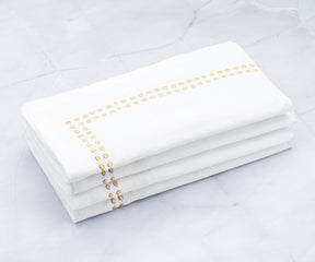 Enhance your dining experience with cloth dinner napkins, personalized and neatly folded, held in a stylish napkin holder. Opt for black dinner napkins for an elegant touch to your table setting.White and Gold Napkins Elegantly Tied with a Twine