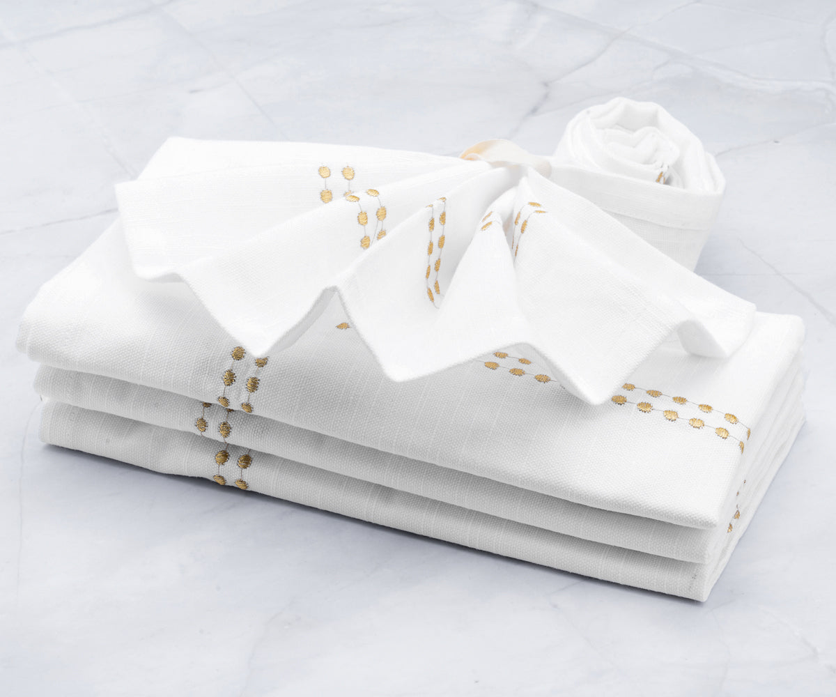 Gold dinner napkins elegantly, including techniques for folding them with rings. White dinner napkins are a classic choice, and they are commonly used during rehearsal dinners.
