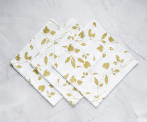 Printed cocktail napkins with pattern of Gold metallic napkins are arranged in white background (white and gold napkins)