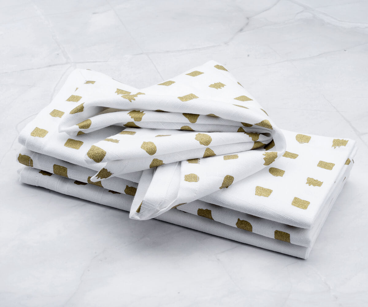 Cloth napkins Gold - metal printed napkins Are folded and  are arranged one above another.