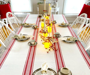Dinner table set with a red and white striped farmhouse tablecloth