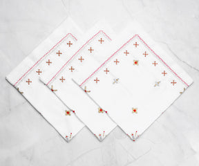 Pure white dinner napkins with a delicate lace trim, adding a vintage charm to the dining table.