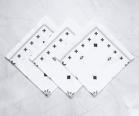 White dinner napkins artistically folded into a rose shape, showcasing creative napkin folding techniques.