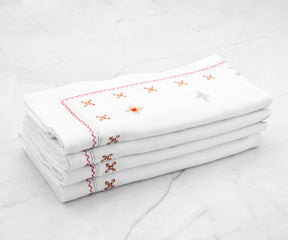 White dinner napkins with a satin band border, perfectly complementing a minimalist table decor.